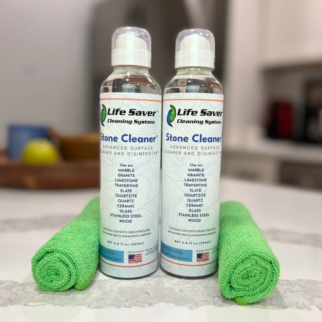 Two pack of Life Saver Stone Cleaner 6.8oz clear bottles with two Life Saver Mini Cloths on white Quartz countertop