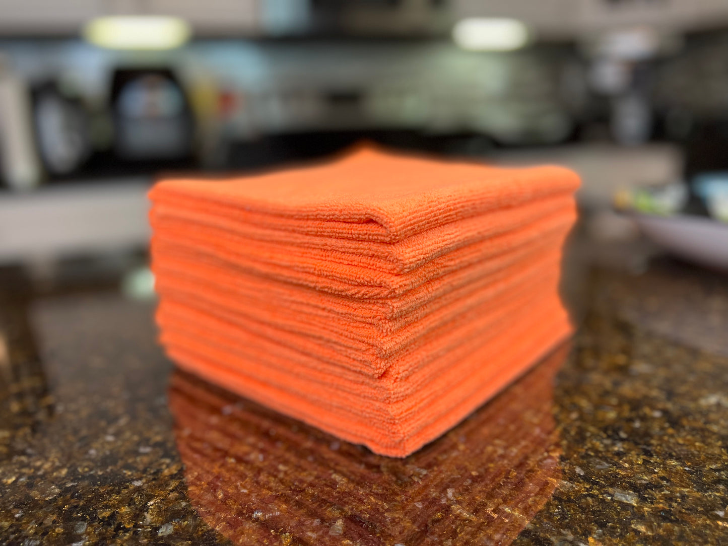 16 inch by 16 inch Orange Life Saver Max Cloths / towels 12 pack angled view on granite countertop