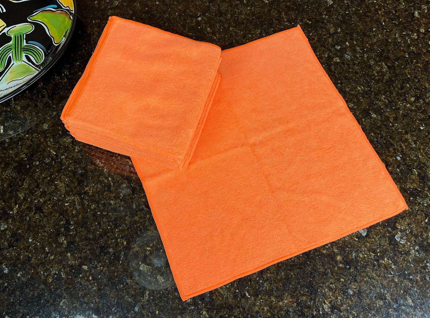 16 inch by 16 inch Orange Life Saver Max Cloths / towels 12 pack  with one open cloth showing size on granite countertop